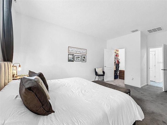 bedroom featuring a spacious closet, light colored carpet, and a closet