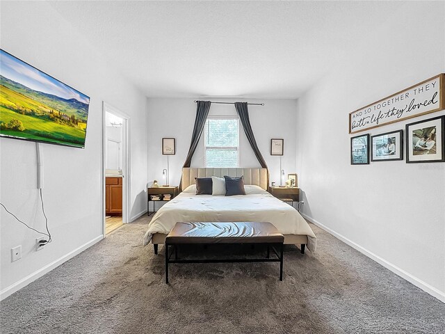 bedroom with ensuite bathroom and carpet