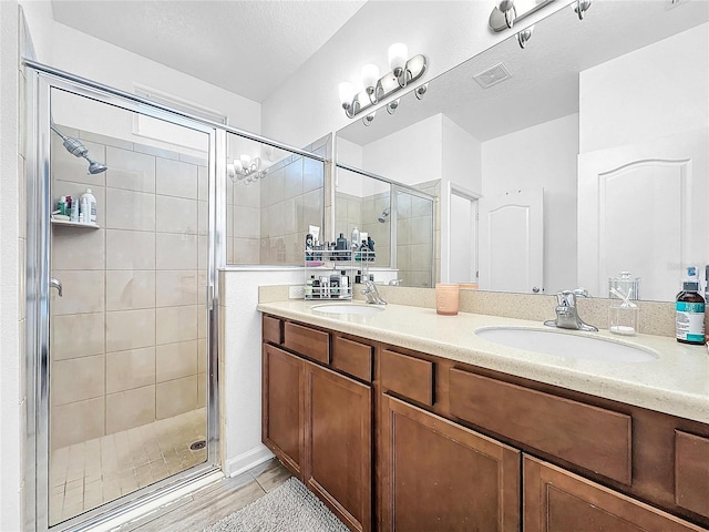 bathroom featuring vanity, a textured ceiling, and walk in shower