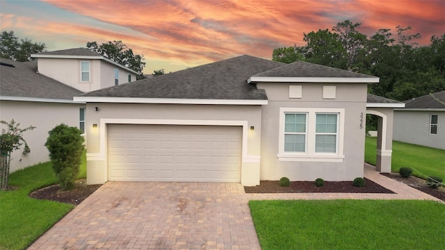 view of front of house with a garage and a yard