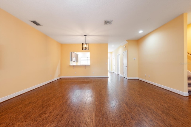 empty room featuring hardwood / wood-style flooring and an inviting chandelier