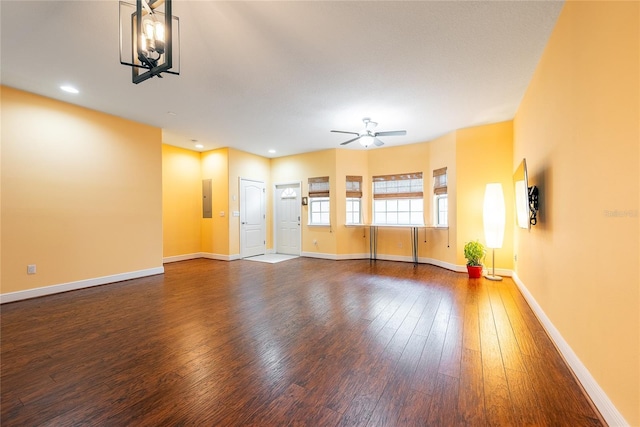 unfurnished living room featuring electric panel, ceiling fan, and dark hardwood / wood-style flooring