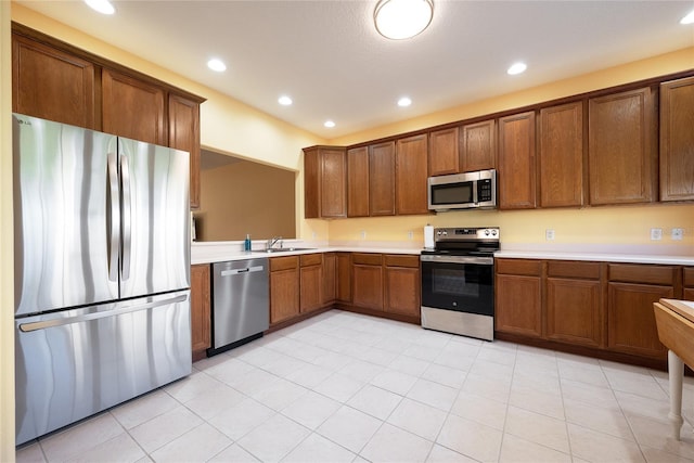 kitchen with sink, light tile patterned flooring, and appliances with stainless steel finishes