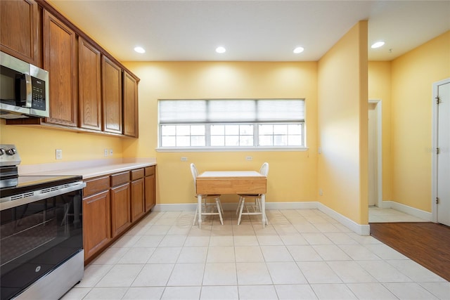 kitchen featuring appliances with stainless steel finishes and light hardwood / wood-style flooring