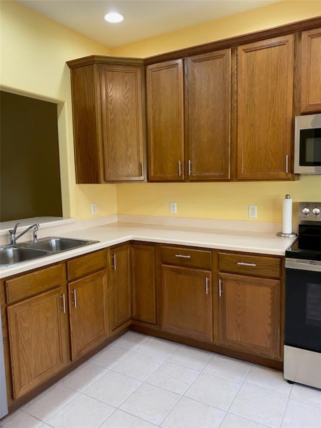 kitchen with sink, light tile patterned flooring, and stainless steel appliances