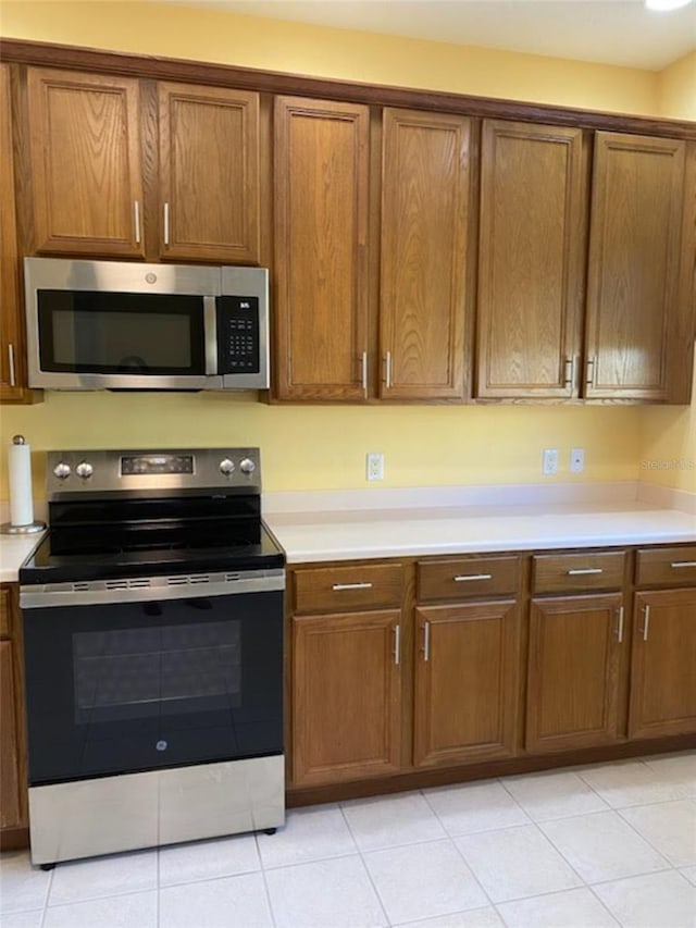 kitchen with light tile patterned flooring and appliances with stainless steel finishes