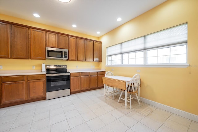 kitchen with light tile patterned flooring and stainless steel appliances