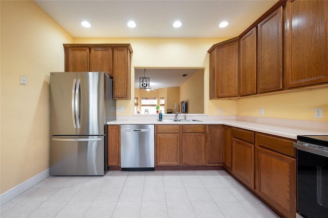 kitchen with stainless steel appliances, sink, pendant lighting, a notable chandelier, and light tile patterned flooring