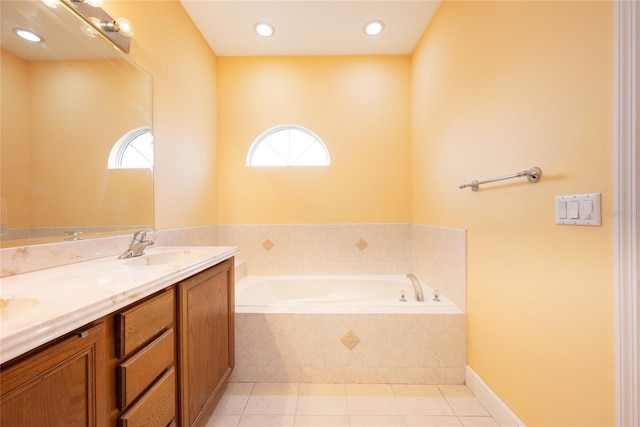 bathroom with tile patterned flooring, vanity, tiled bath, and plenty of natural light