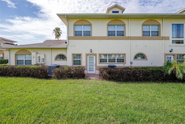 view of front of home featuring cooling unit and a front yard