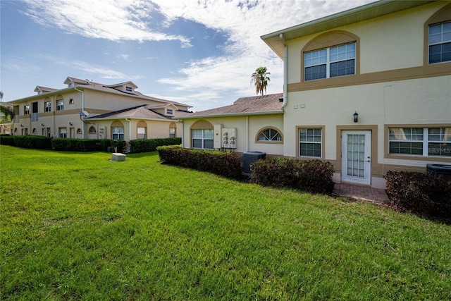 exterior space with a lawn and central AC