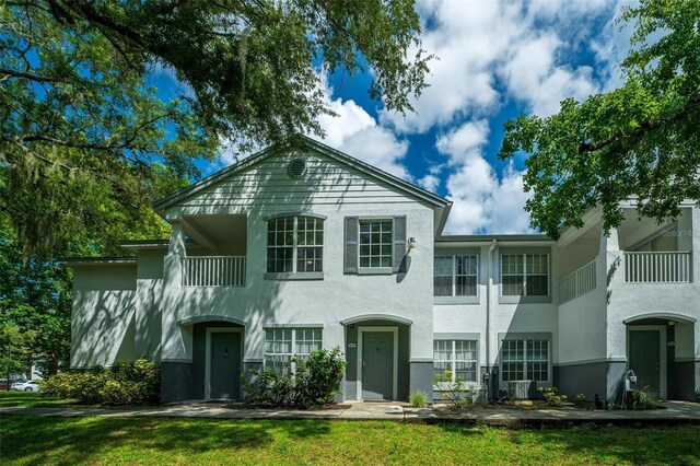 view of front facade featuring a balcony and a front lawn