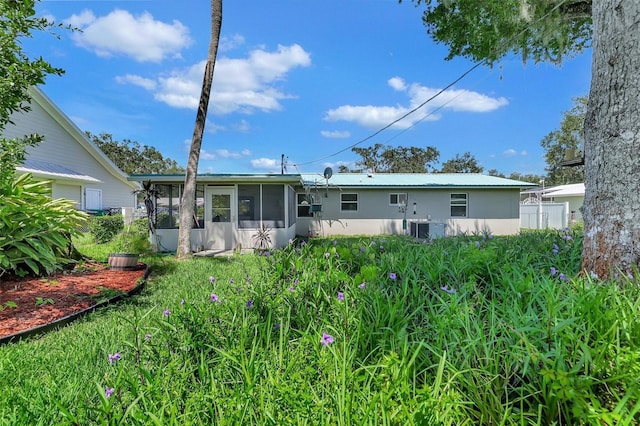 rear view of property featuring cooling unit and a sunroom