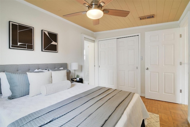 bedroom featuring ornamental molding, a closet, light parquet flooring, and wood ceiling