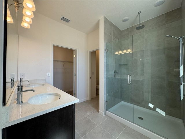 bathroom with tile patterned floors, vanity, toilet, and an enclosed shower