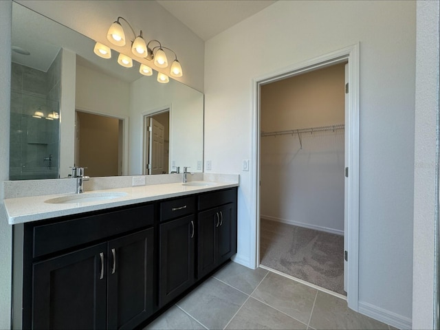 bathroom with tile patterned flooring, vanity, and walk in shower