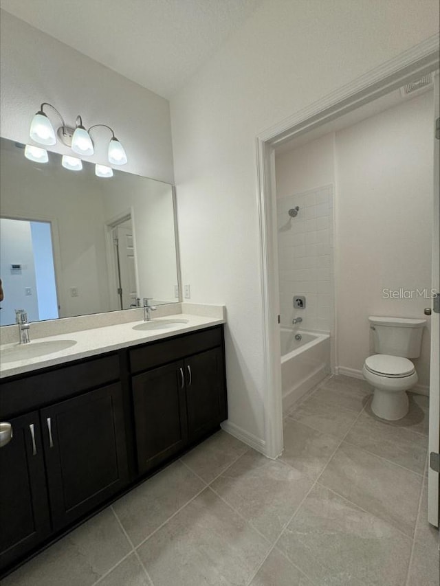 bathroom with double vanity, shower / tub combination, toilet, and a sink