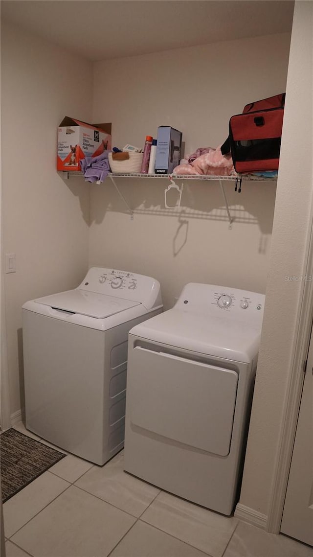 washroom with washing machine and dryer and light tile patterned floors