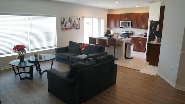 living room featuring sink and light hardwood / wood-style flooring