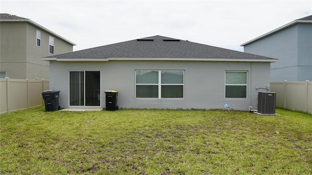 back of property featuring a yard and central air condition unit