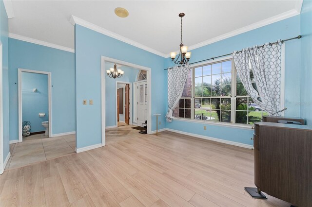 unfurnished dining area with crown molding, a chandelier, and light wood-type flooring