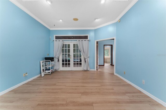 unfurnished room featuring light hardwood / wood-style flooring, crown molding, and french doors