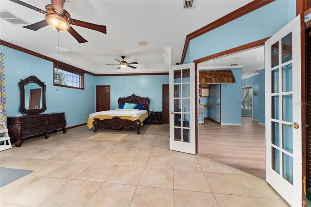 bedroom with ornamental molding, light hardwood / wood-style flooring, french doors, ceiling fan, and a raised ceiling