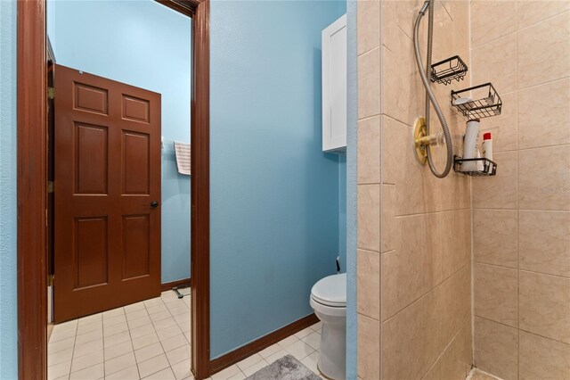 bathroom featuring tiled shower, toilet, and tile patterned floors