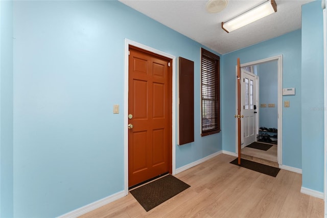 entrance foyer with a textured ceiling and light hardwood / wood-style flooring