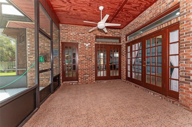 unfurnished sunroom with ceiling fan, wooden ceiling, and french doors