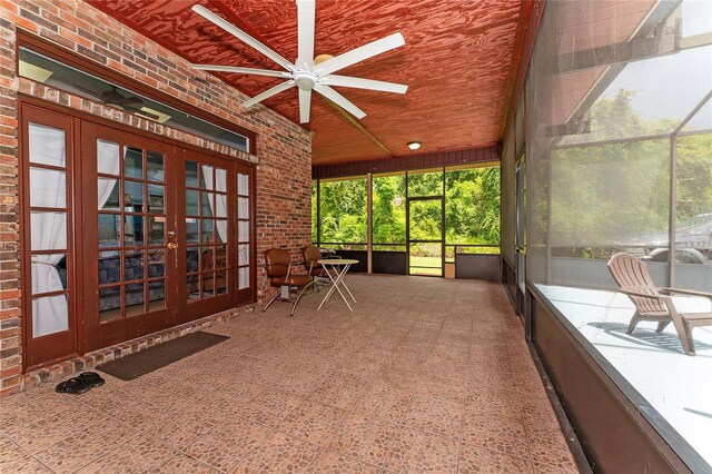 unfurnished sunroom with ceiling fan, wood ceiling, and french doors