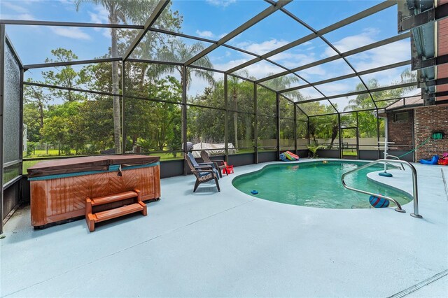 view of swimming pool featuring a hot tub, glass enclosure, and a patio