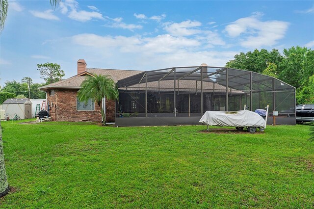 rear view of property featuring glass enclosure and a lawn