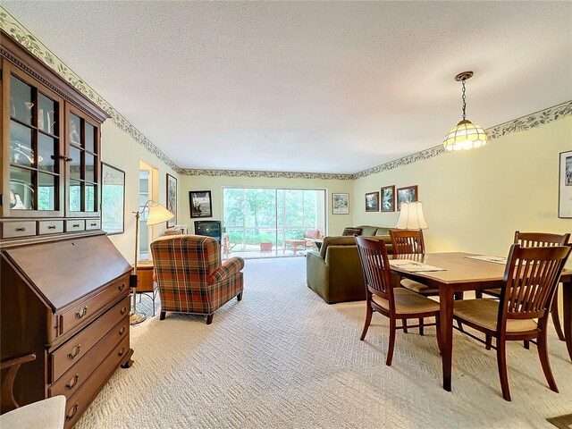 carpeted dining space with a textured ceiling