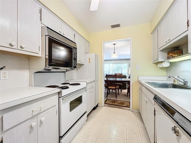 kitchen featuring sink, white appliances, decorative light fixtures, and white cabinets