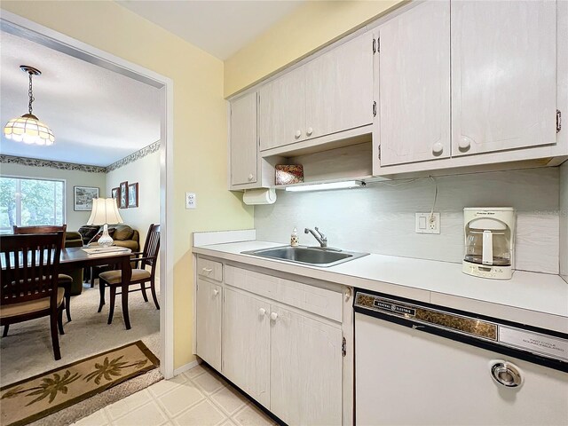 kitchen with pendant lighting, sink, dishwasher, white cabinetry, and tasteful backsplash