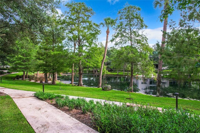 view of home's community with a water view and a lawn