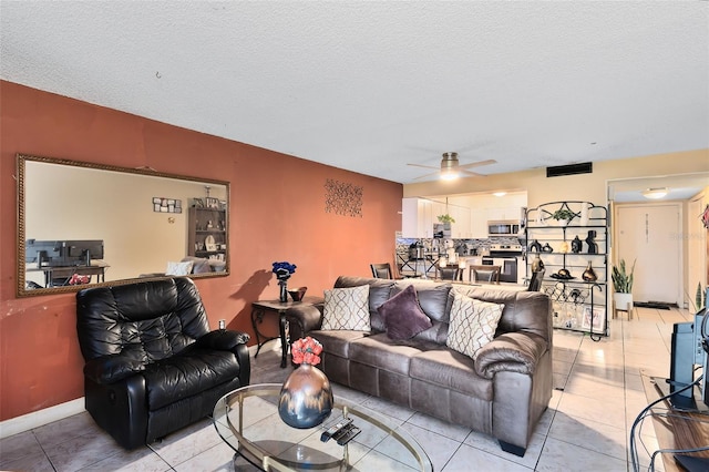 tiled living room featuring a textured ceiling and ceiling fan