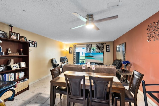 dining room featuring a textured ceiling, light tile patterned floors, and ceiling fan