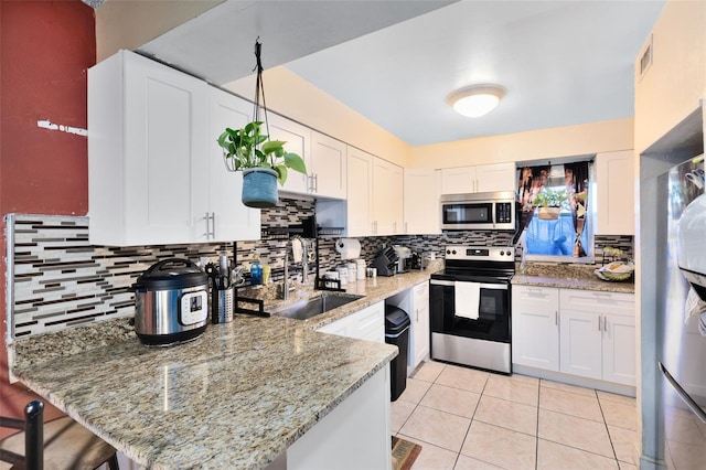 kitchen with sink, white cabinetry, tasteful backsplash, and stainless steel appliances