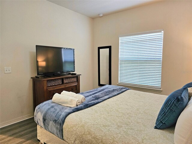 bedroom with dark hardwood / wood-style flooring