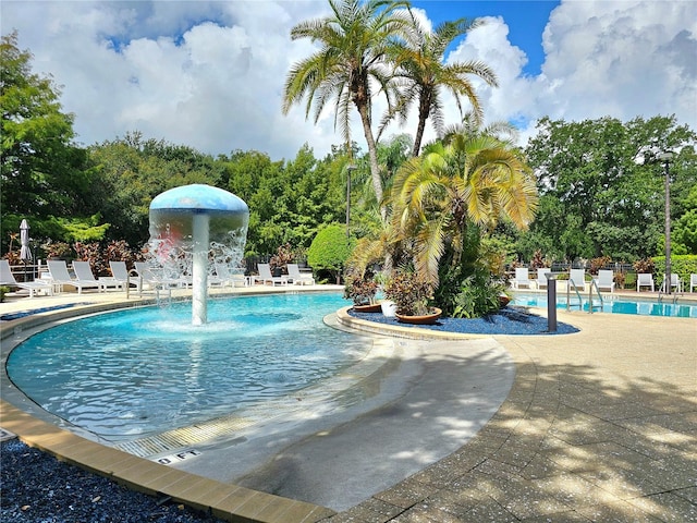 view of pool with a patio and pool water feature