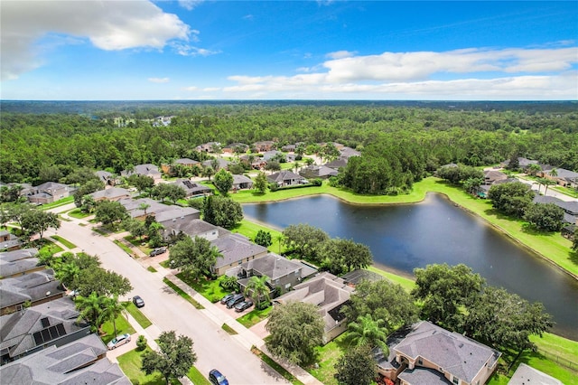 drone / aerial view with a water view, a wooded view, and a residential view