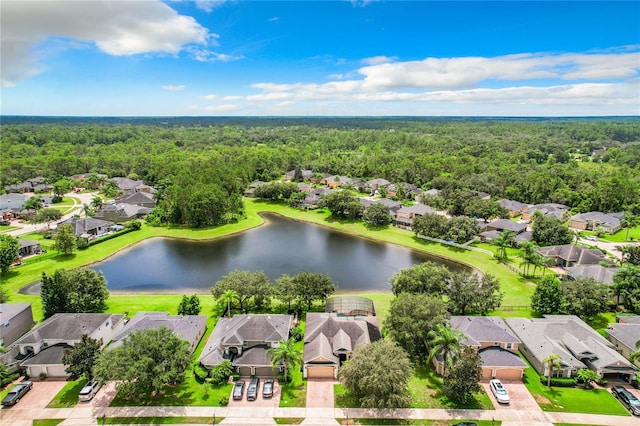 drone / aerial view with a water view, a residential view, and a view of trees