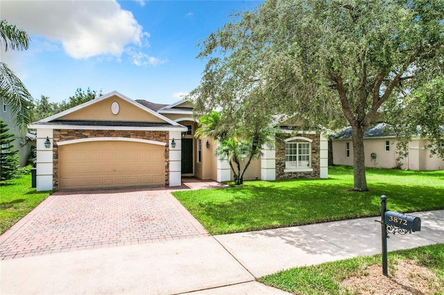 single story home with decorative driveway, stucco siding, an attached garage, stone siding, and a front lawn