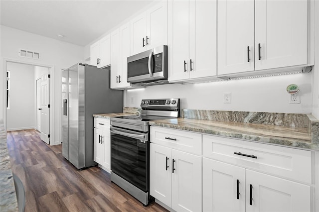 kitchen with dark hardwood / wood-style flooring, white cabinets, light stone counters, and stainless steel appliances