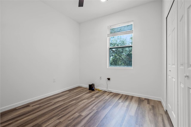 unfurnished bedroom featuring ceiling fan, wood-type flooring, and a closet