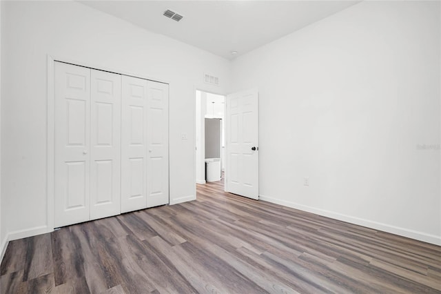 unfurnished bedroom with a closet and hardwood / wood-style floors