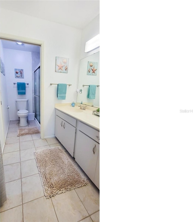 bathroom featuring a shower with shower door, vanity, tile patterned flooring, and toilet