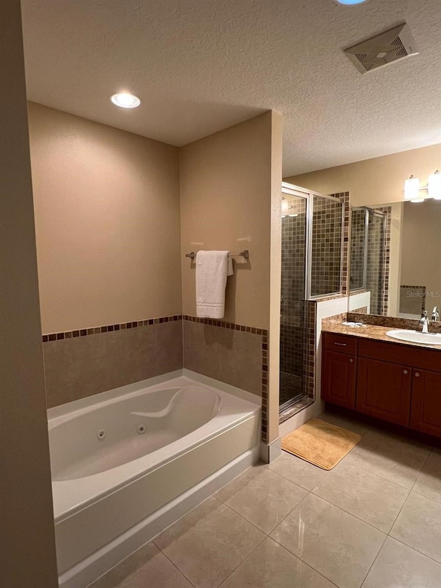 bathroom featuring plus walk in shower, tile patterned floors, a textured ceiling, and vanity